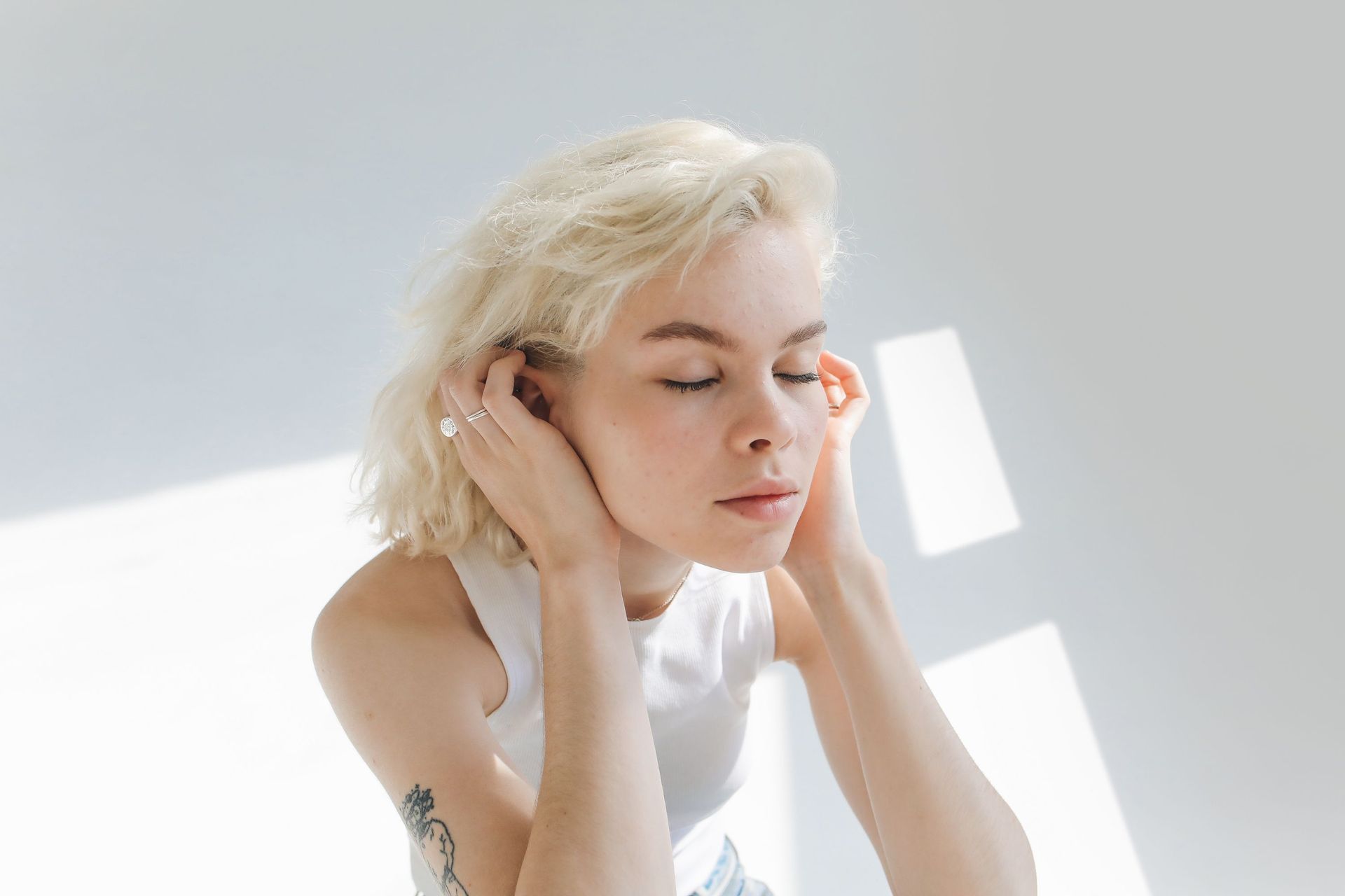 Woman holding her hand to a blocked ear
