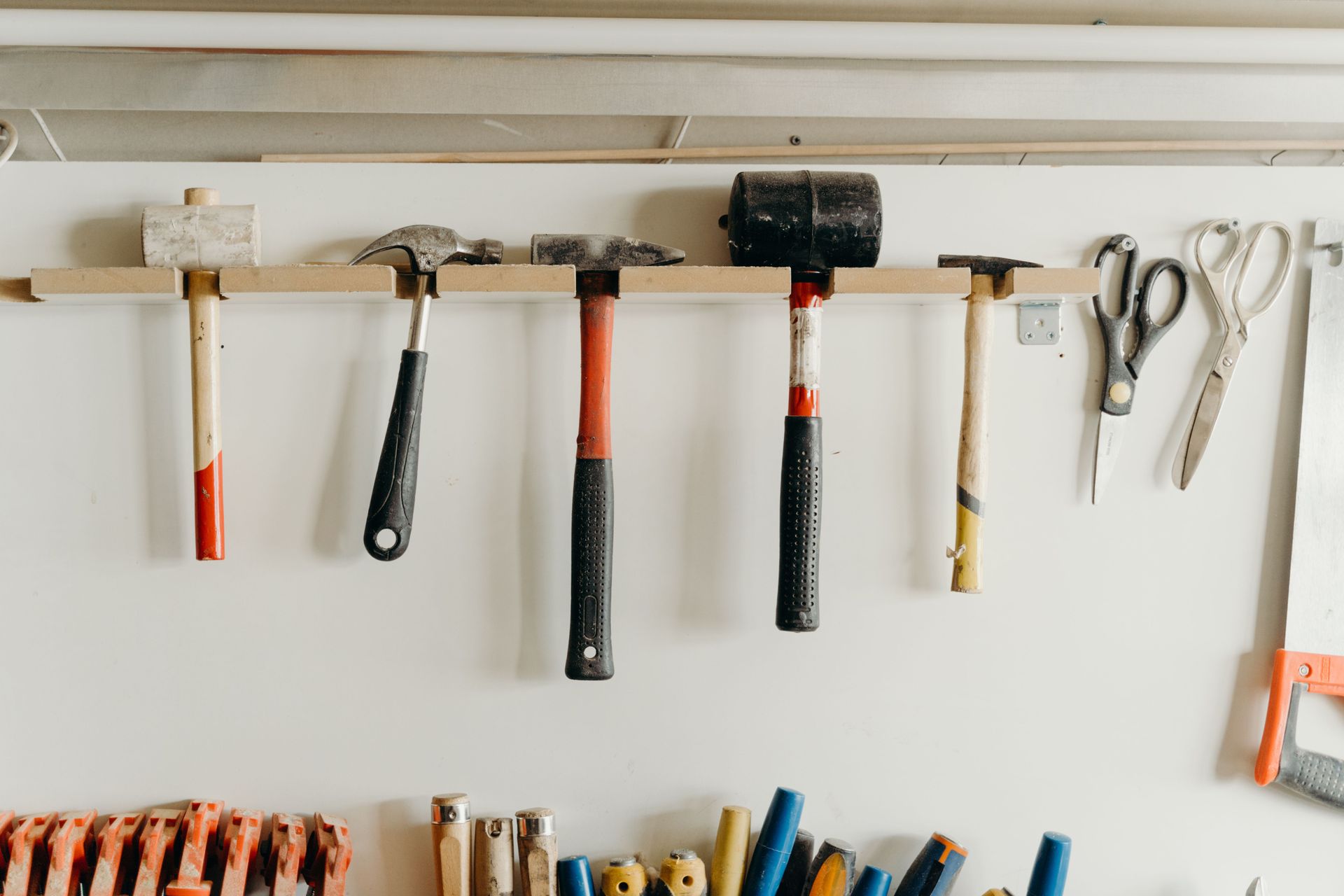 Hammers and hand tools hanging on a workshop wall