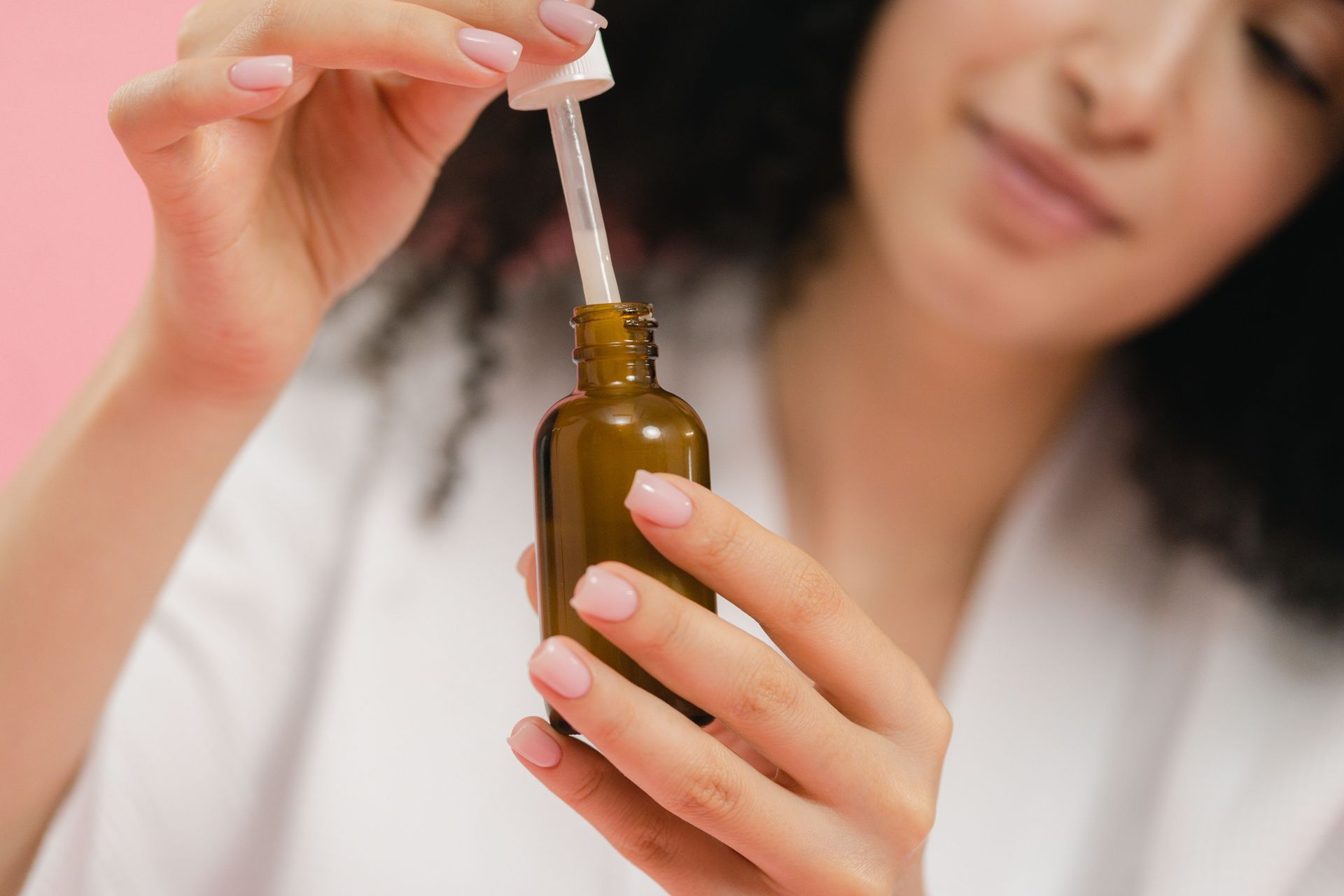 Woman holding a dropper bottle of skincare serum