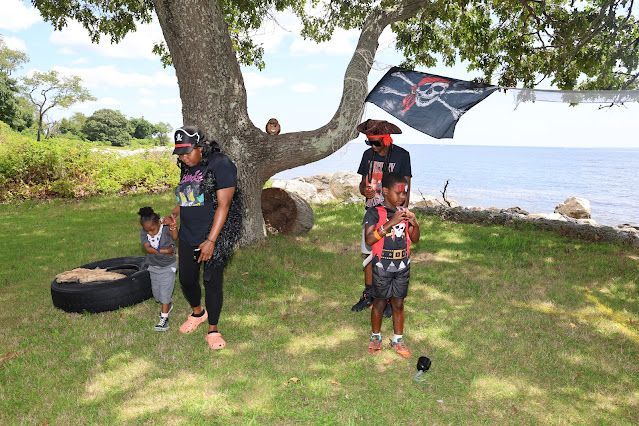 A family is flying a pirate kite in a park.