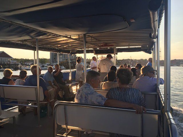 A group of people are sitting on the back of a boat.