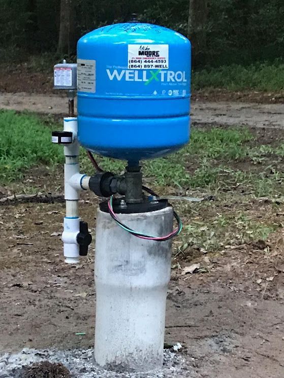 A blue water tank is sitting on top of a white pipe.