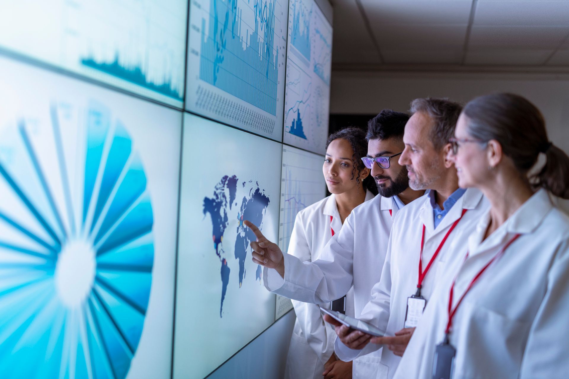 A group of doctors are looking at a large screen. A group of doctors are looking at a large screen.