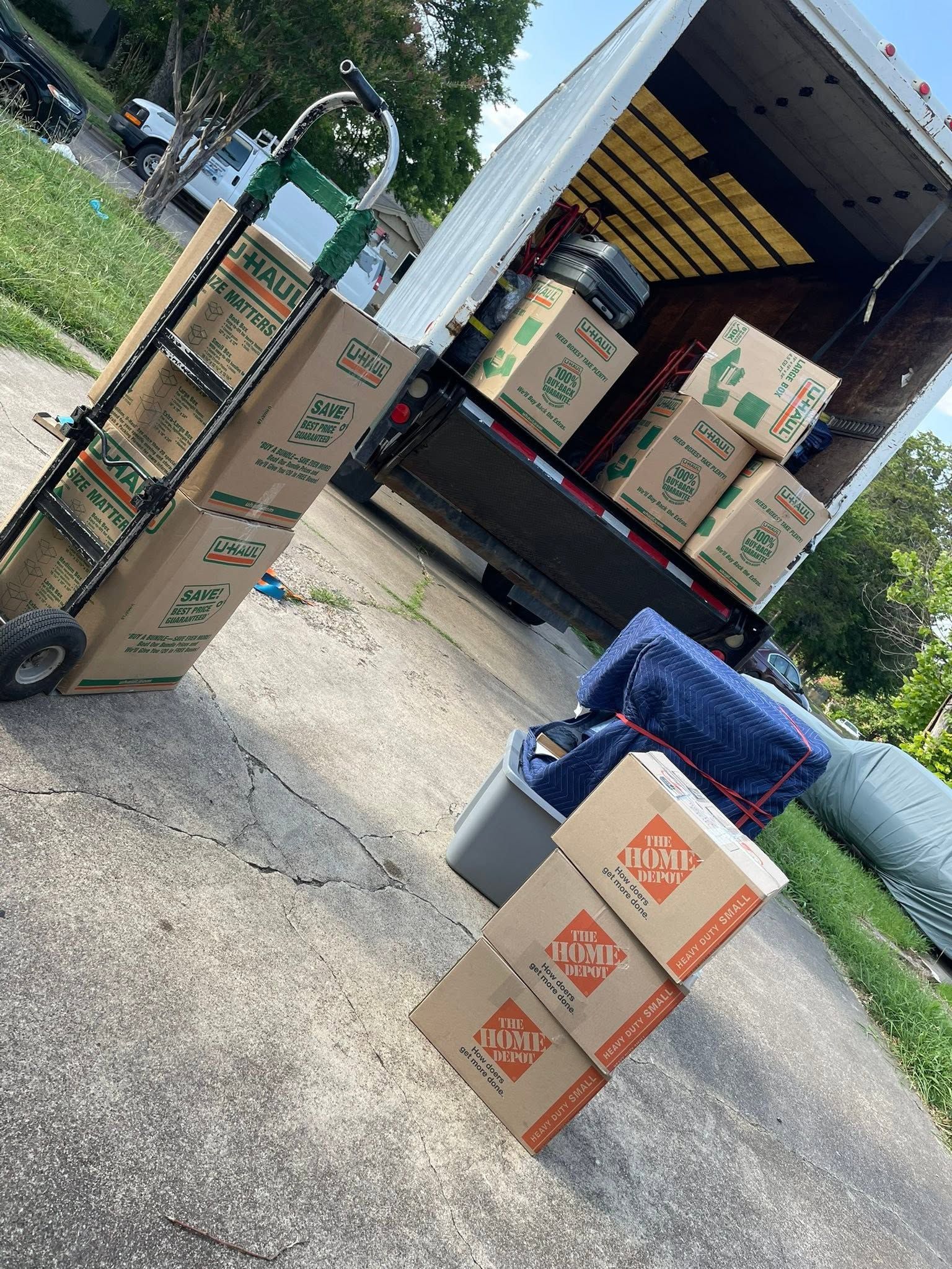 Boxes being loaded onto a moving truck at a warehouse driveway