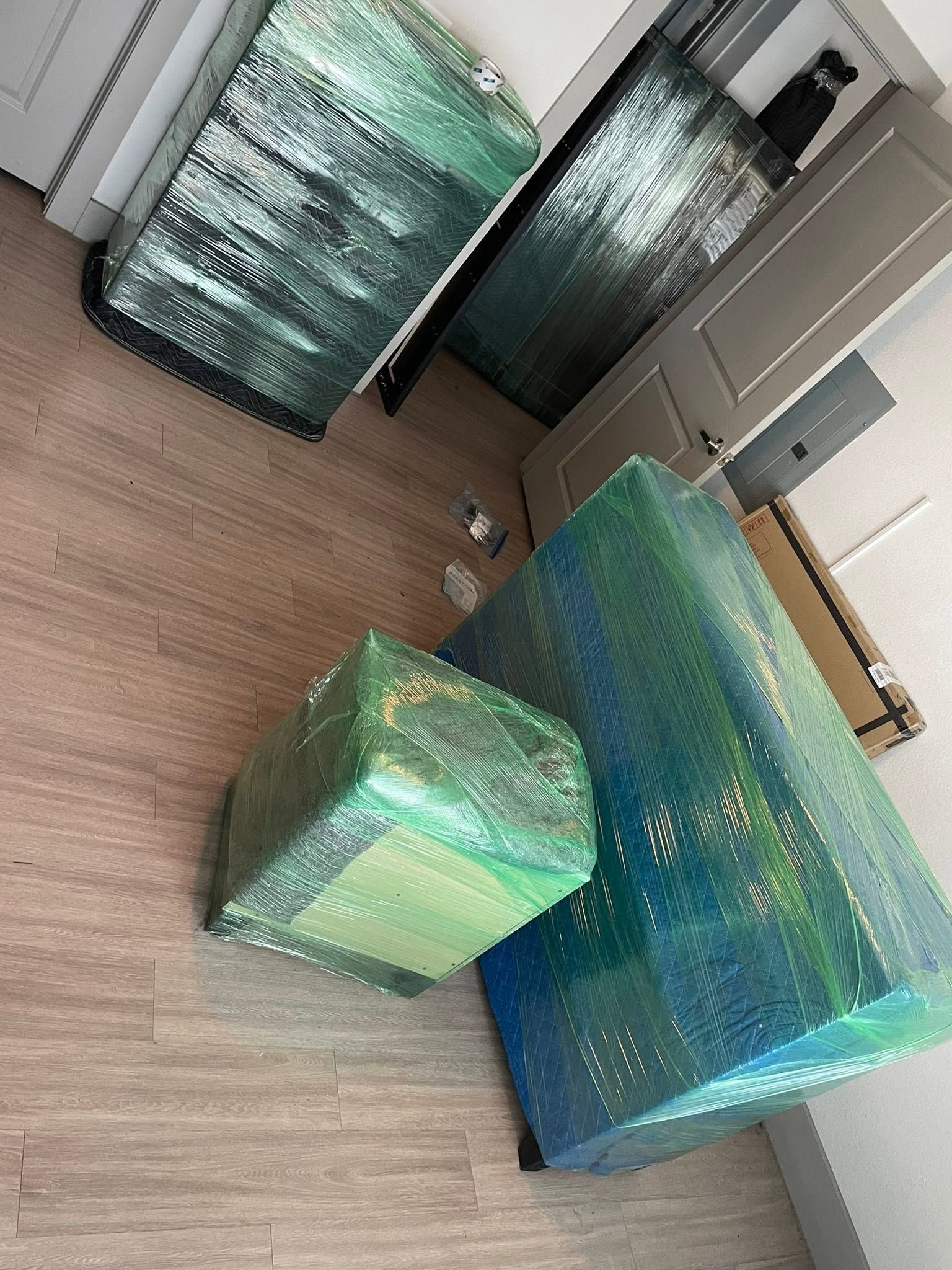 Wrapped gift boxes in iridescent green and blue sit on a carpeted floor in a room.