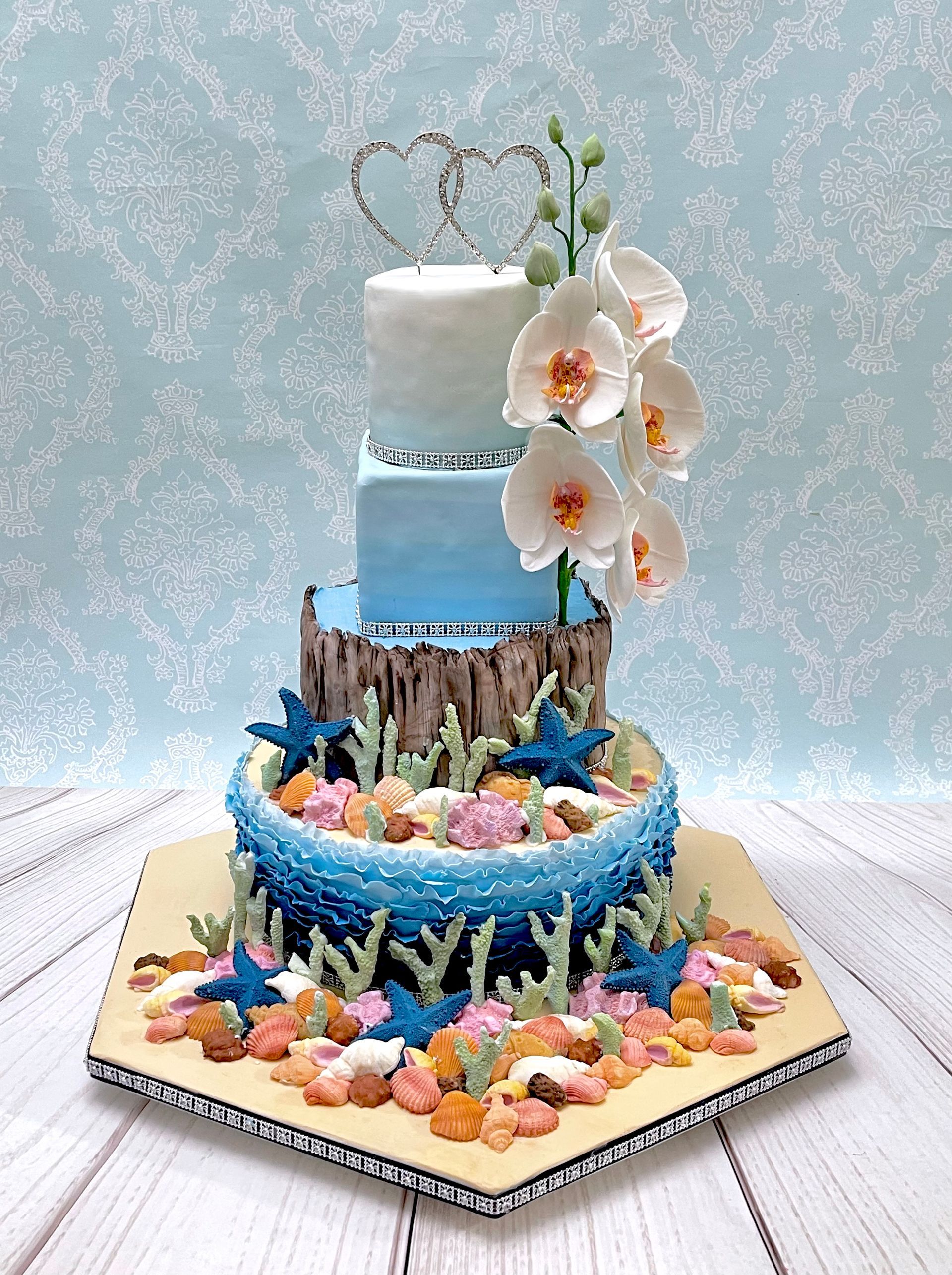 4 tier wedding cake Port Macquarie. With Sugar shells, sugar coral, sugar drift wood sugar orchids, diamante heart topper and trim.