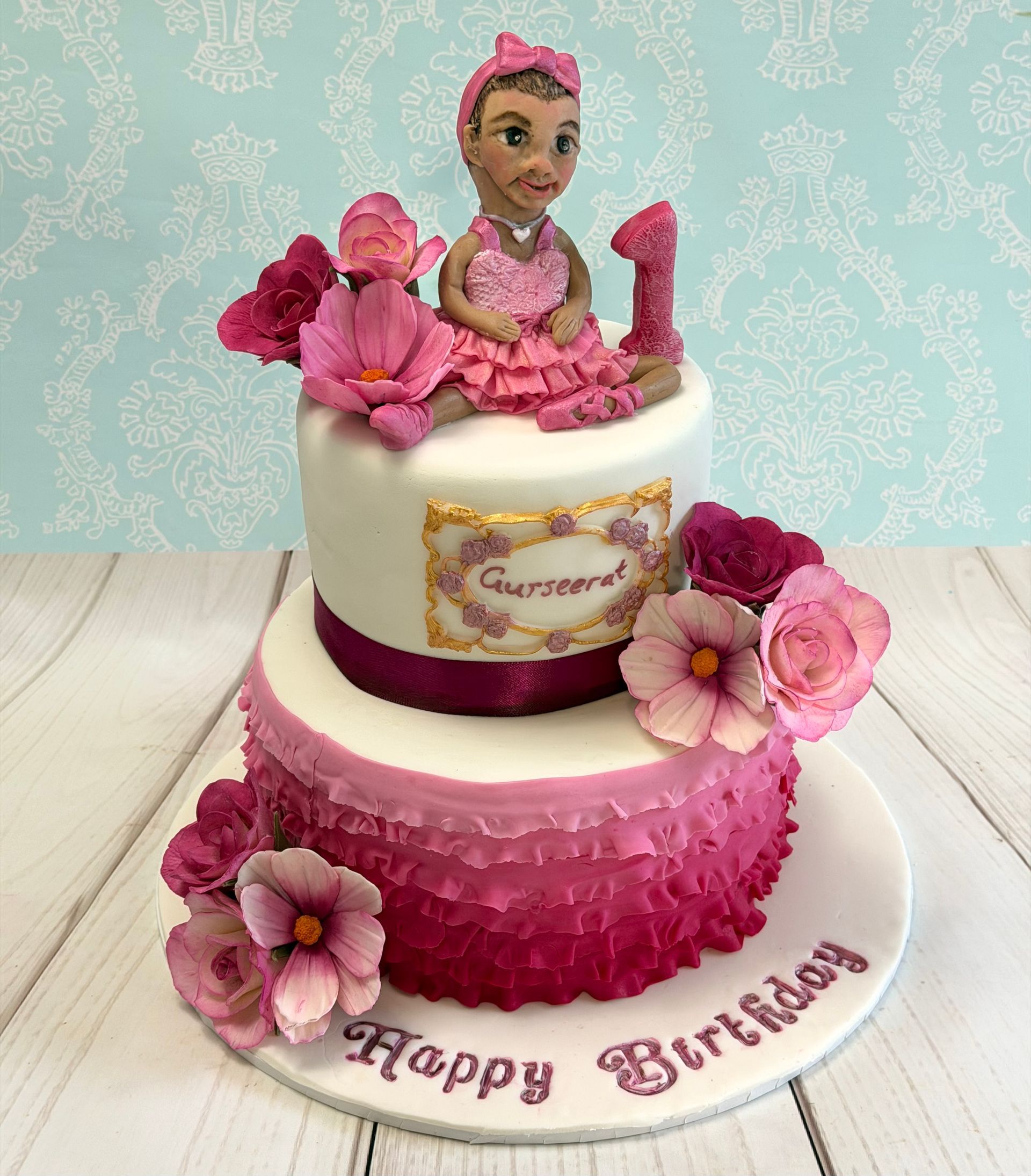 First 1st Birthday Cake Port Macqaurie 2 tier pink and white ruffles pink and white sugar flowers roses and cosmos flowers, and a hand sculpted pretty girl topper plus sentiments. 