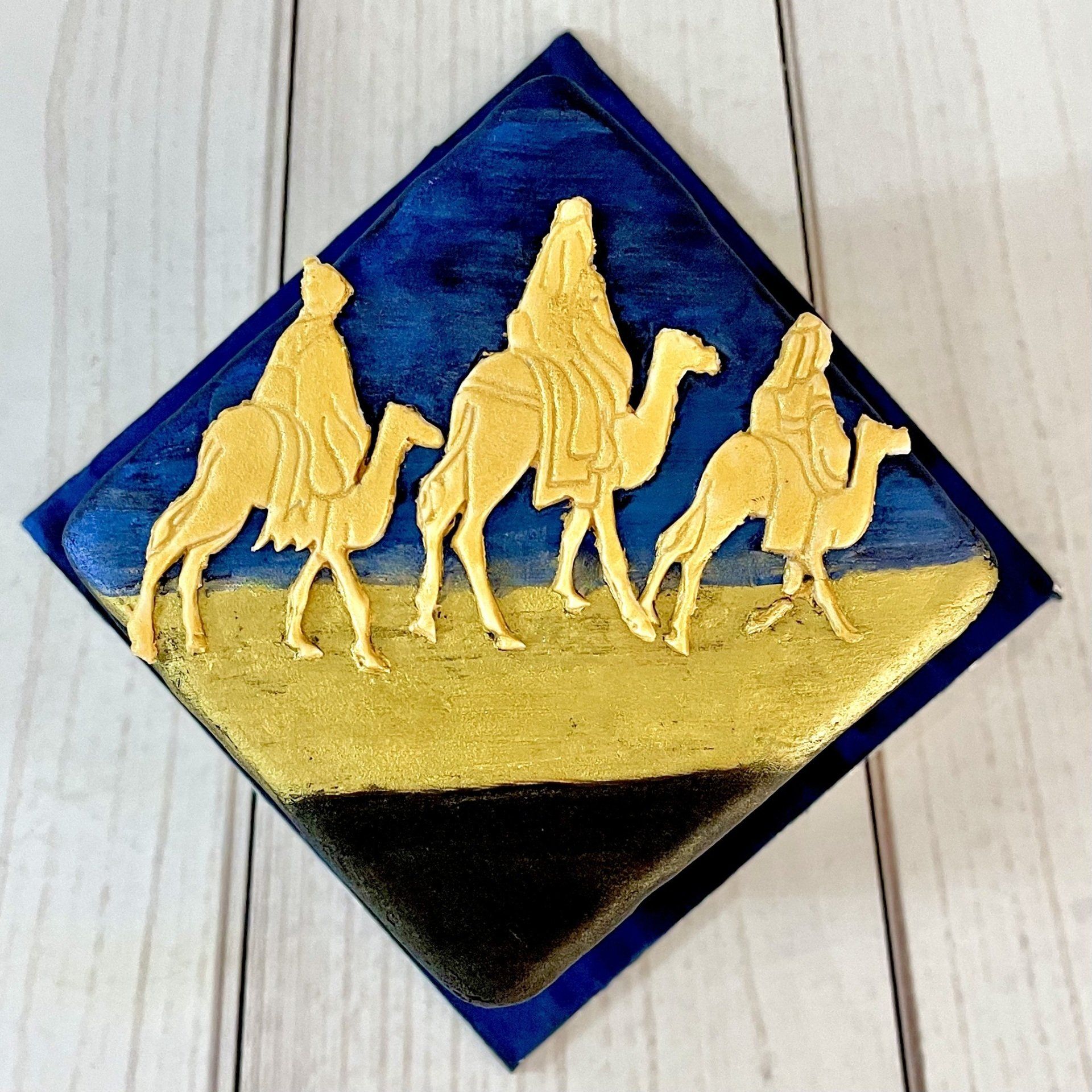 Christmas cake with 3 wise men riding camels at night.