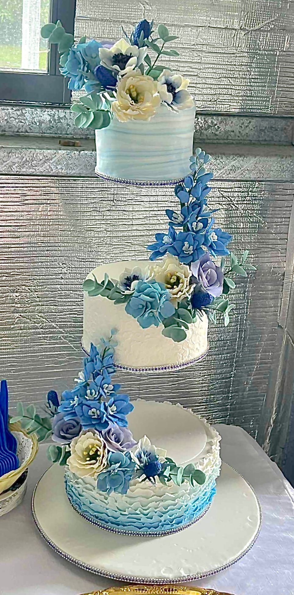 3 tier floating sapphire wedding anniversary cake with textured fondant and handmade sugar flowers in shades blue.