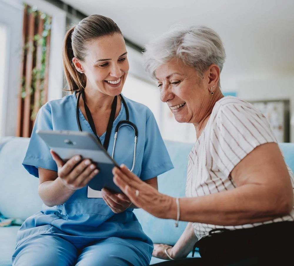 Nurse showing a tablet to an elderly patient in a bright clinic, both smiling.