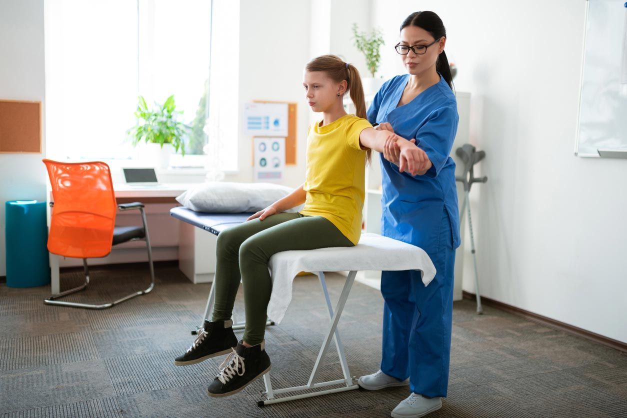 Therapist assisting a child on a treatment table in a bright clinic room
