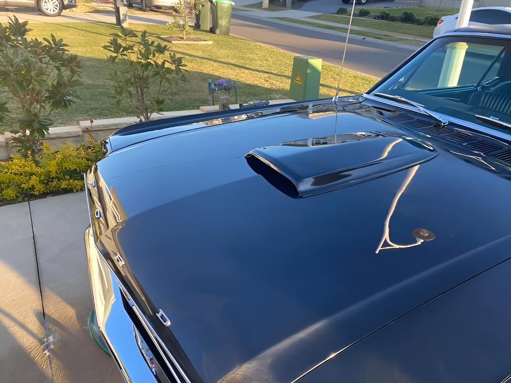 A Black Car With A Hood Scoop Is Parked In A Driveway — All Clean Auto Detailing In Caves Beach, NSW