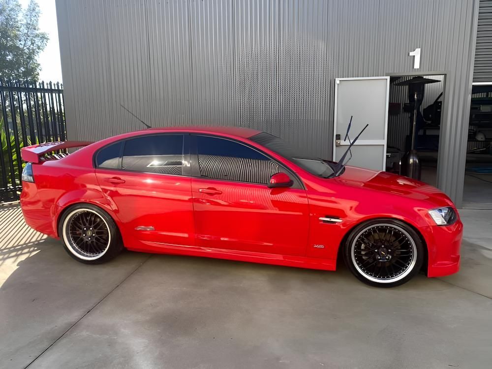 A Red Car Is Parked In Front Of A Building With The Number 1 On It — All Clean Auto Detailing In Caves Beach, NSW