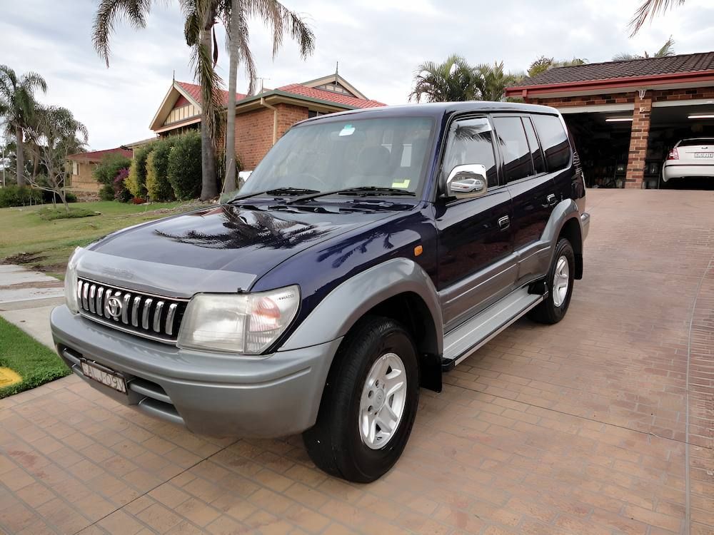 A Blue Suv Is Parked In A Driveway In Front Of A House — All Clean Auto Detailing In Caves Beach, NSW