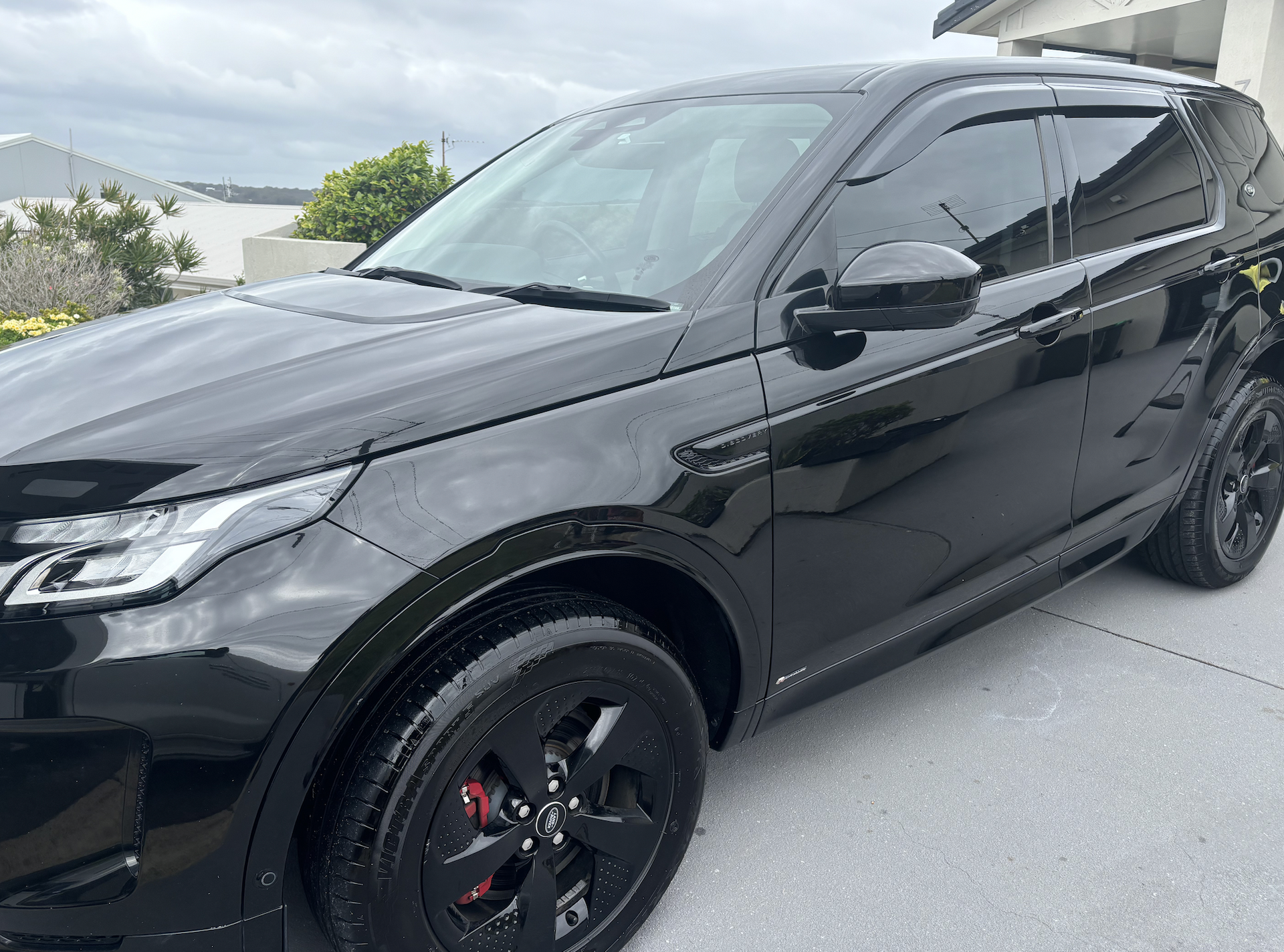 A Person Is Polishing The Hood Of A Blue Car — All Clean Auto Detailing In Summerland Point, NSW