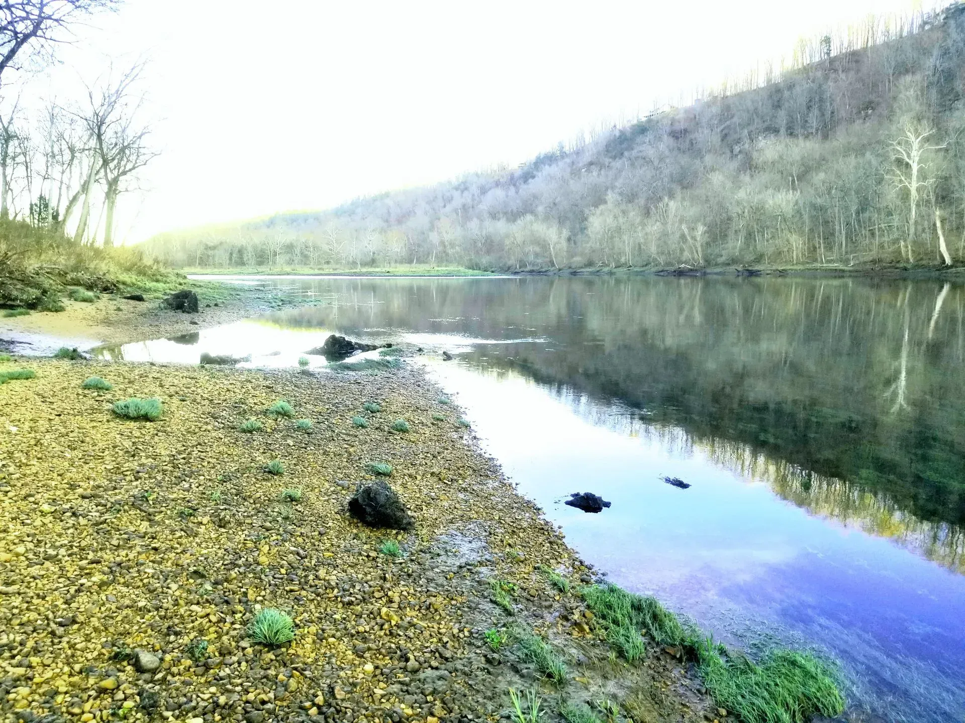 A large body of water surrounded by trees and rocks.