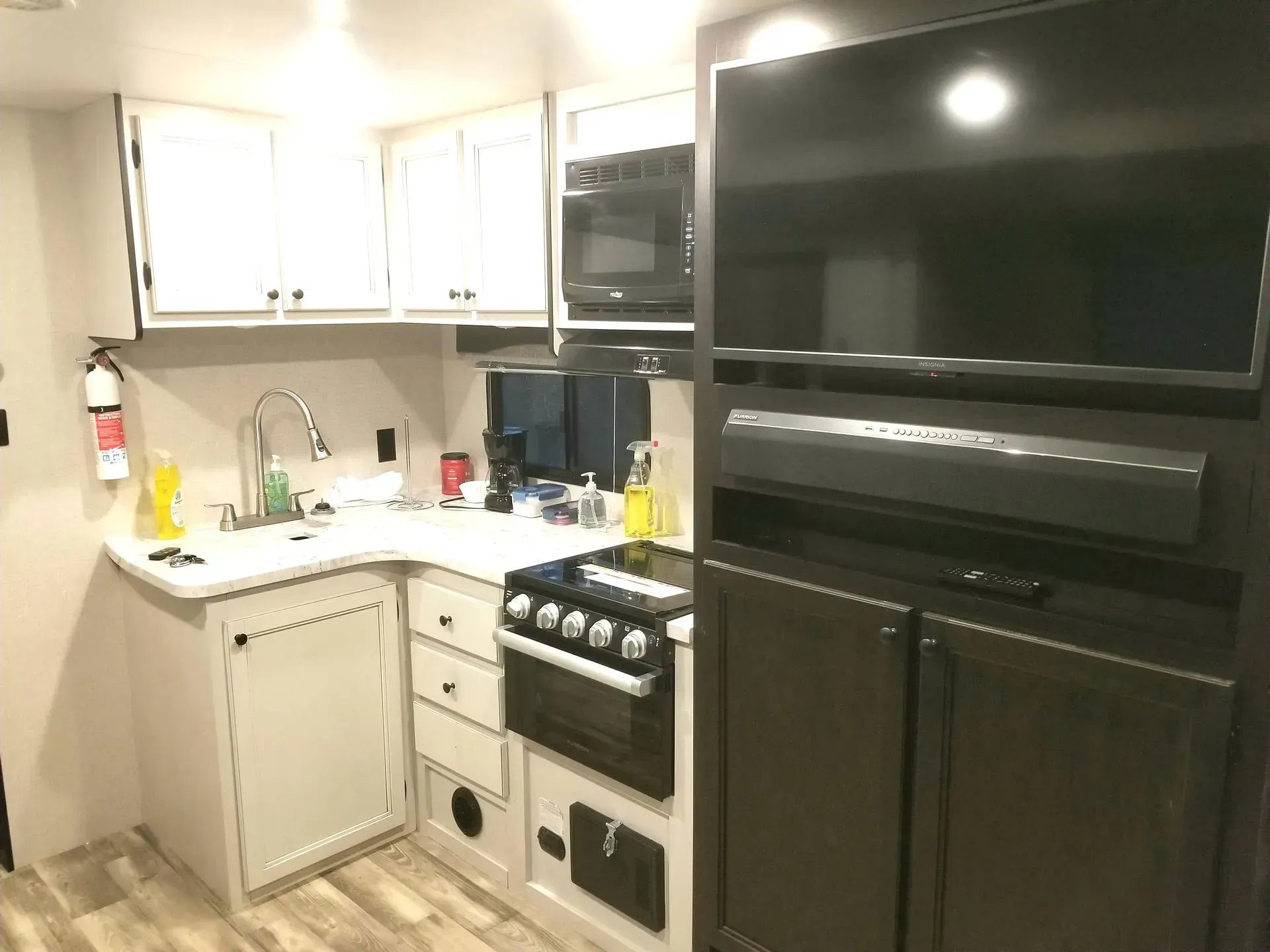 rv kitchen with a stove , refrigerator , microwave and television.
