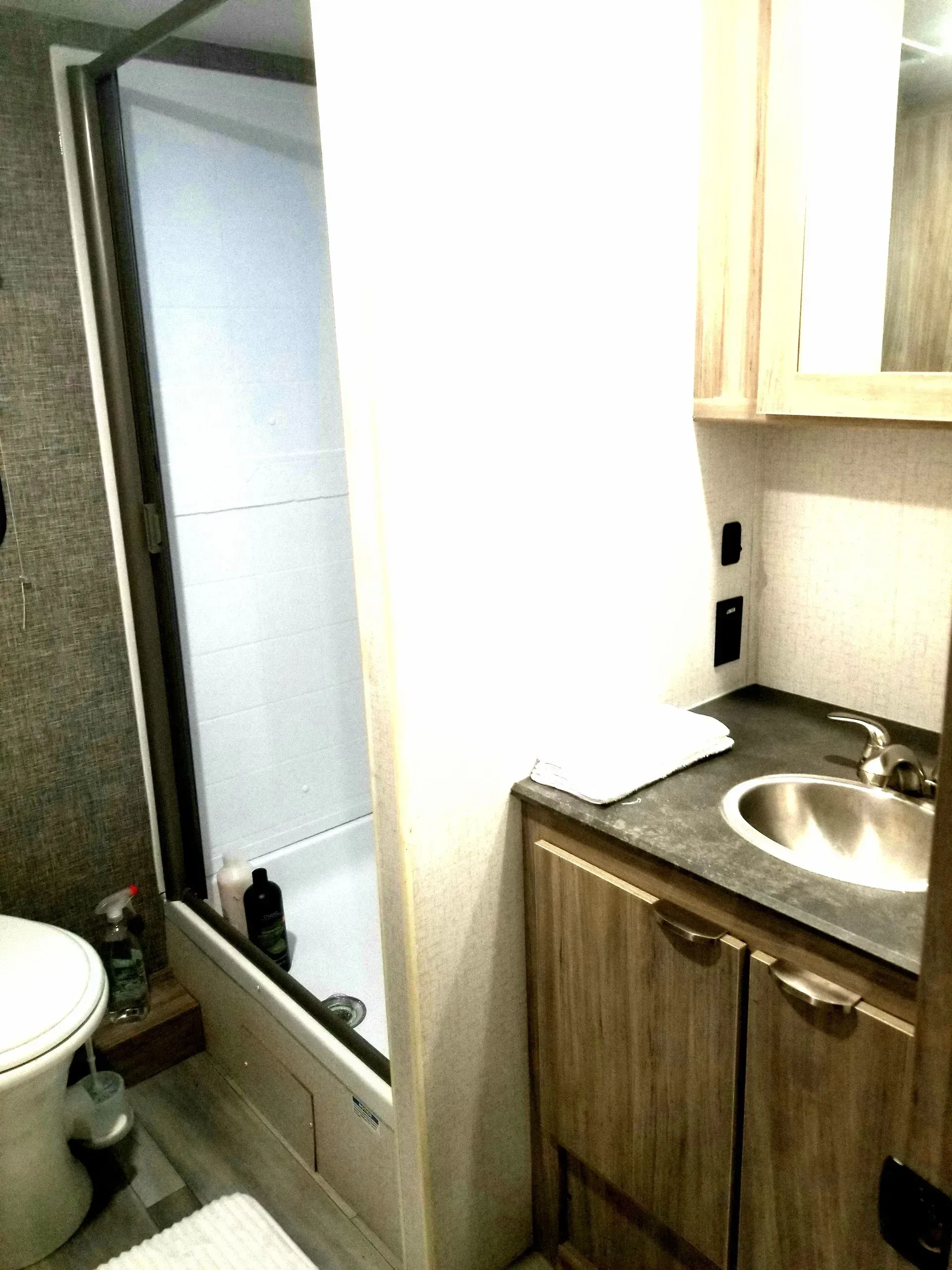 A bathroom with a toilet a sink and a shower