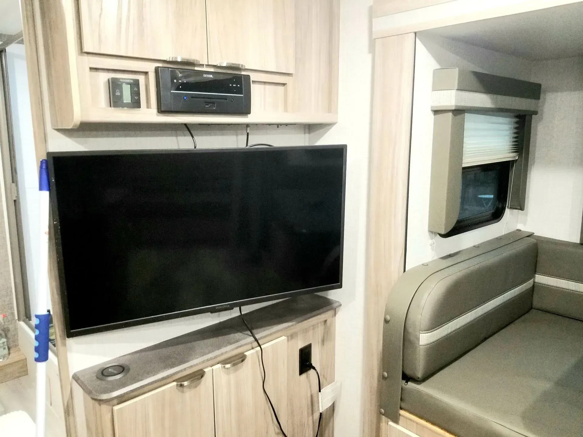 A flat screen tv is mounted on a cabinet in a rv.