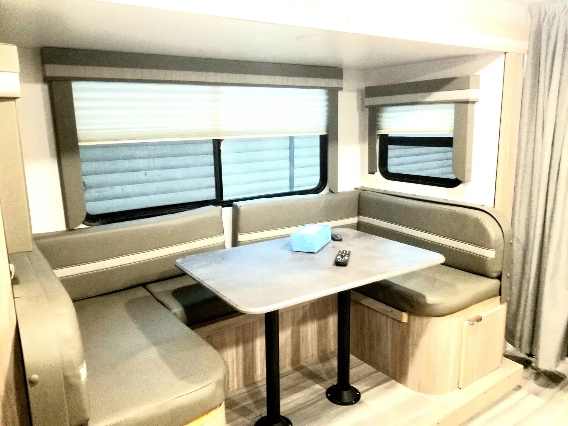 A rv with a table and a couch in it.