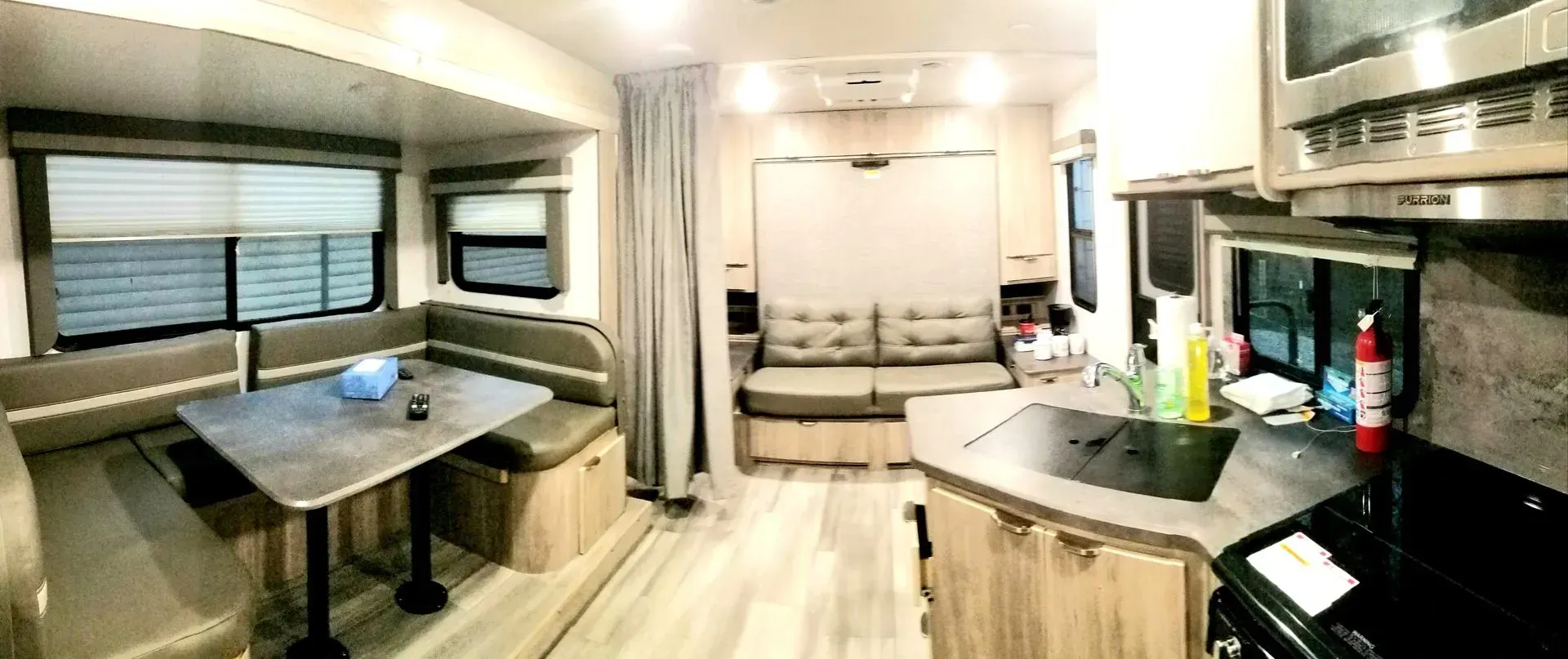 A rv with a kitchen , dining room , and living room.