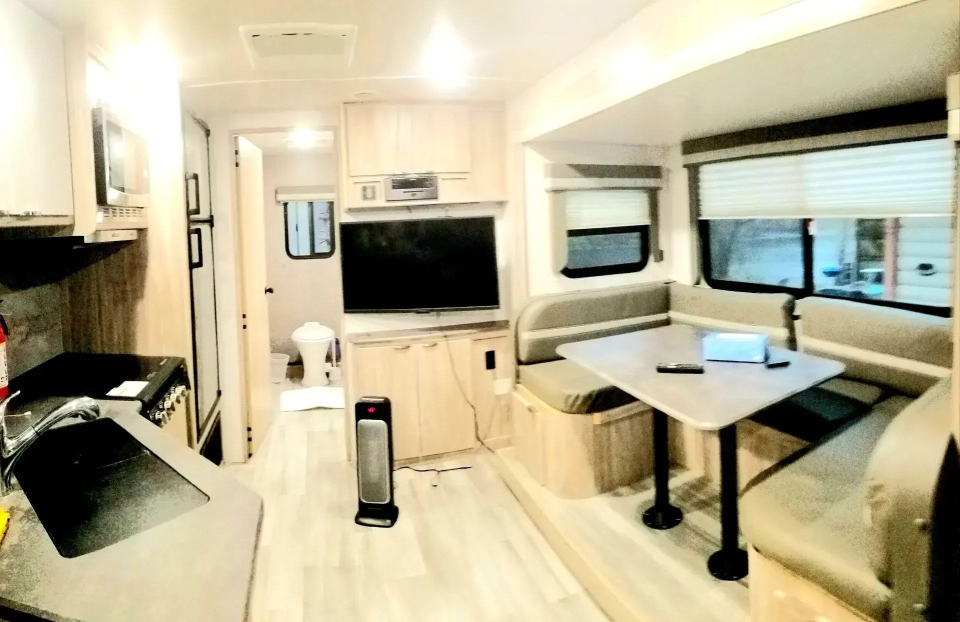 The inside of a rv with a table and couch.