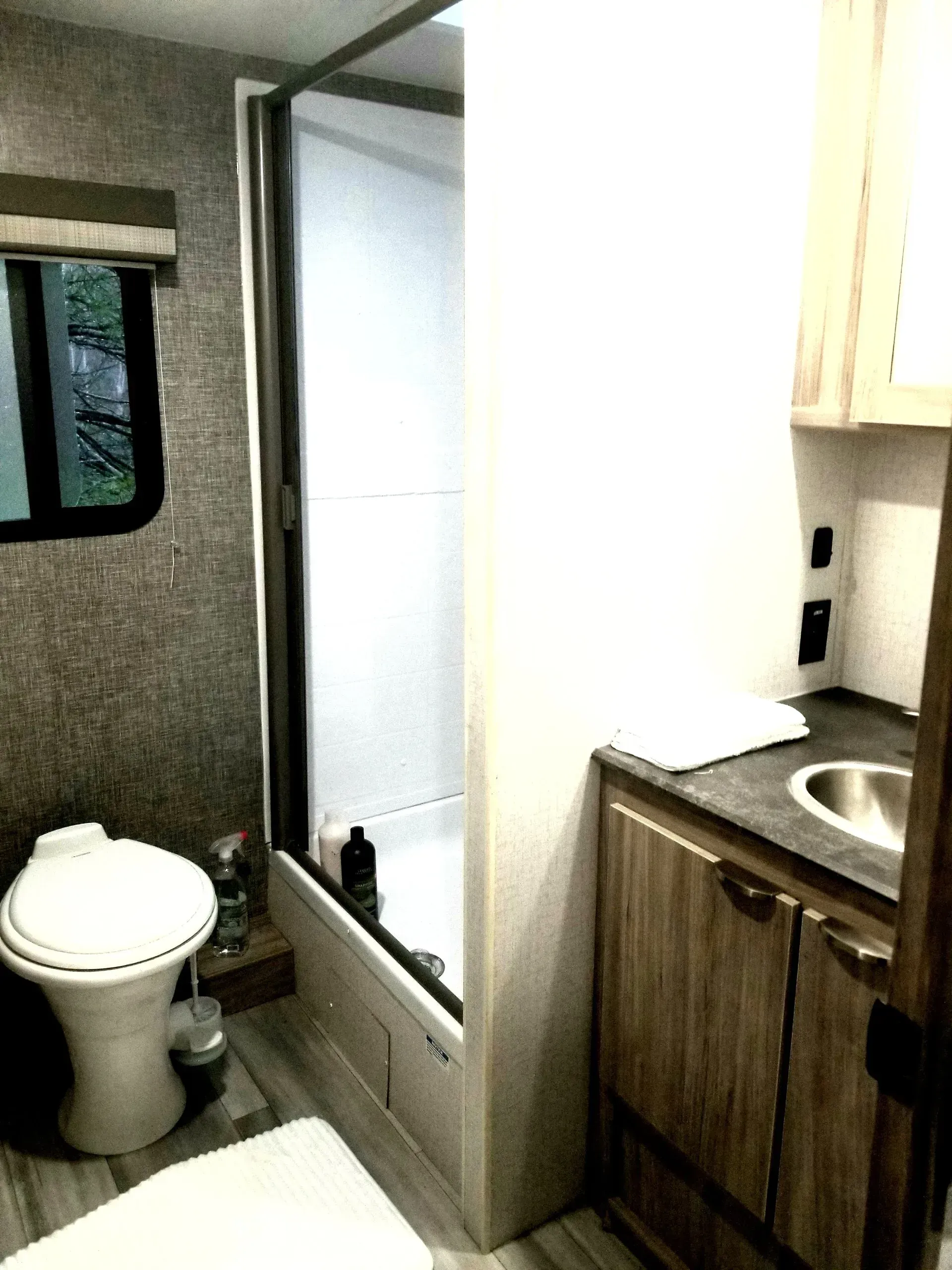 A bathroom with a toilet , sink , and shower.