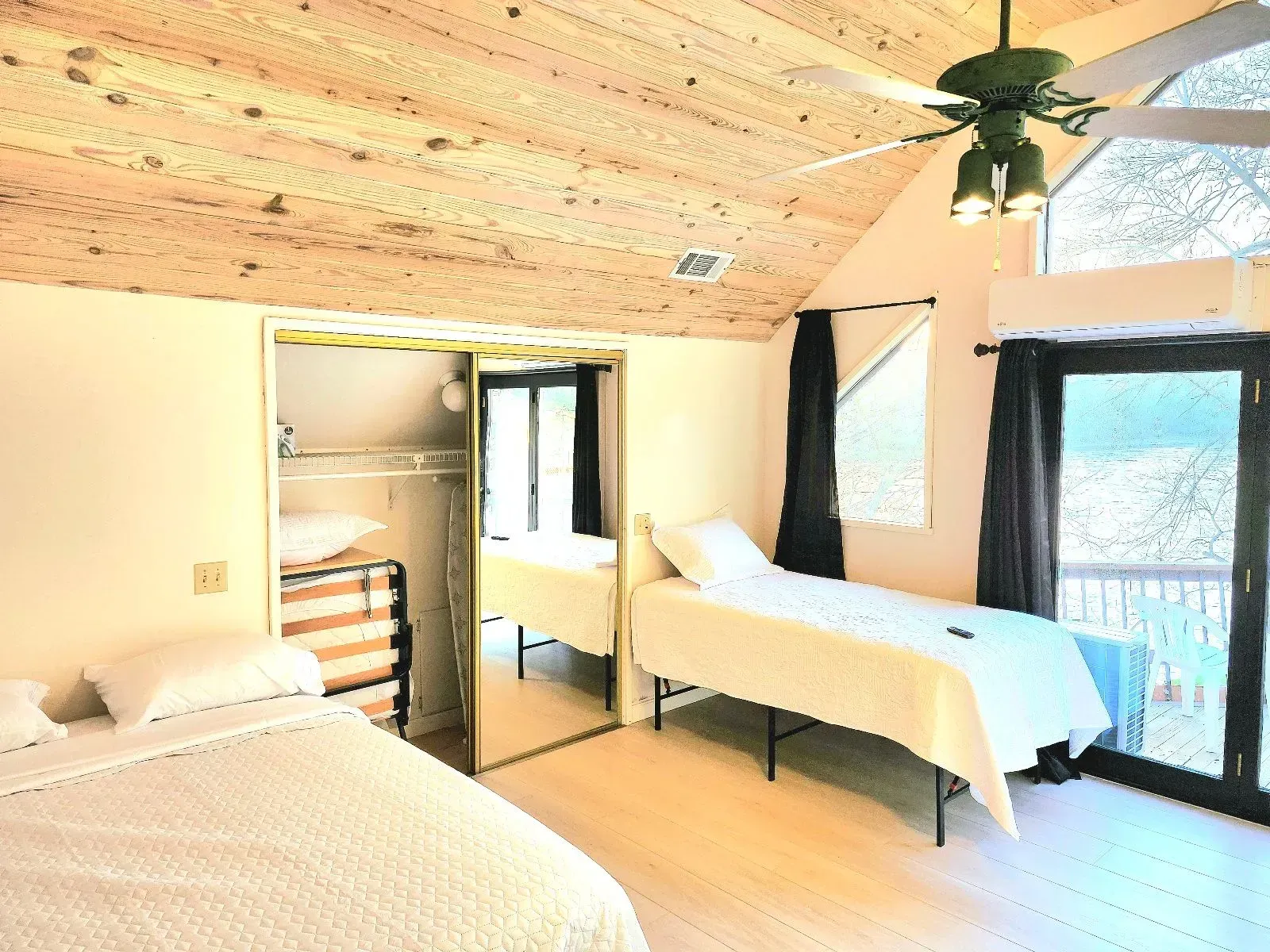 A bedroom with two beds and a ceiling fan.