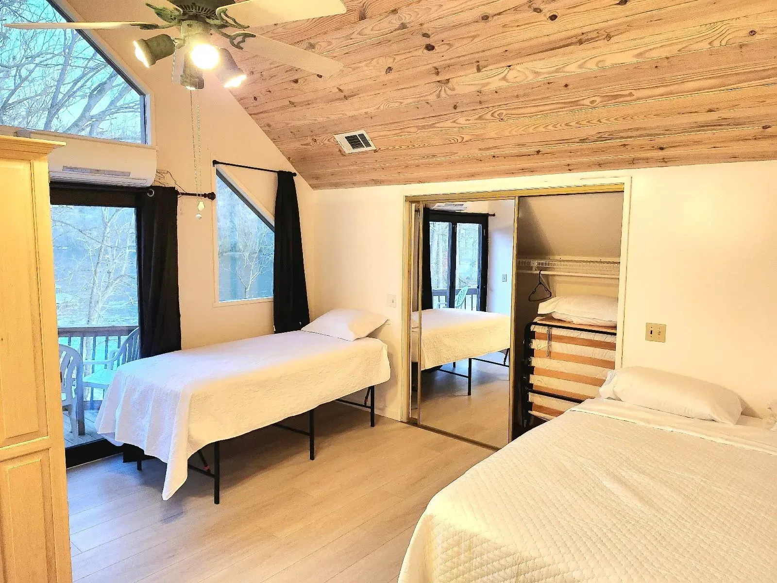A bedroom with two beds and a ceiling fan