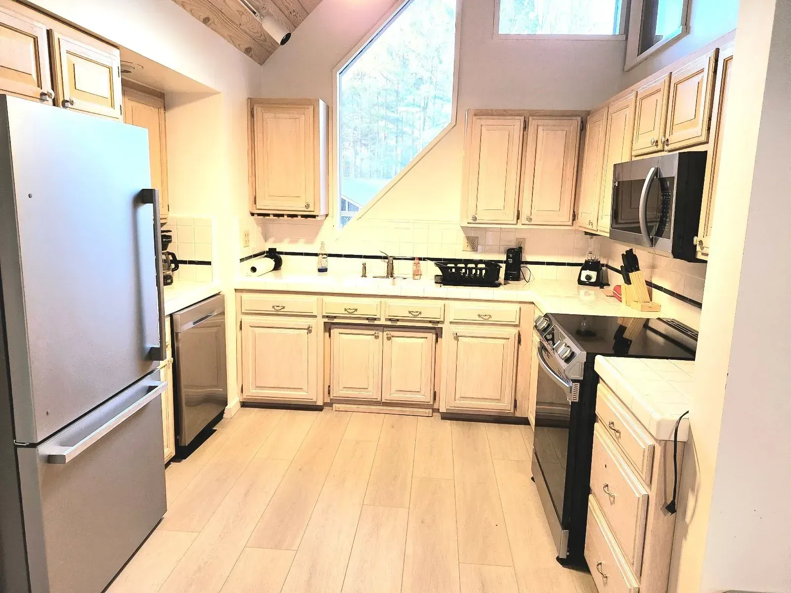 A kitchen with white cabinets and stainless steel appliances