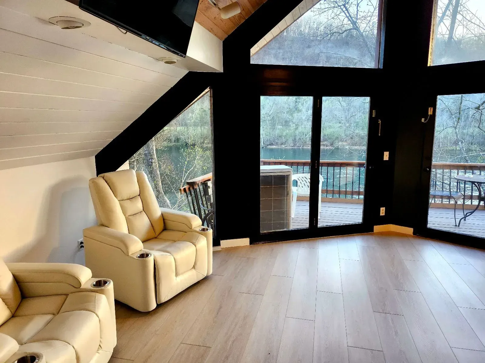 A living room with a lot of windows and chairs