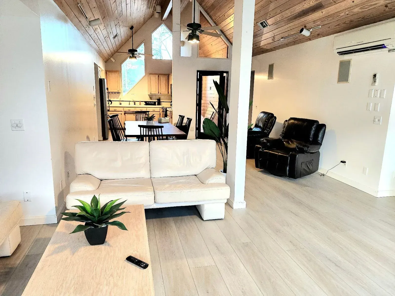 A living room with a couch , chairs , and a table.