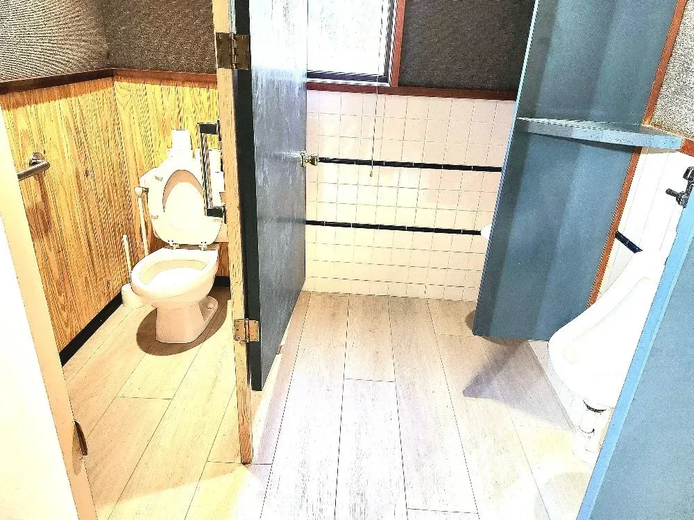 A bathroom with a toilet and a urinal in it