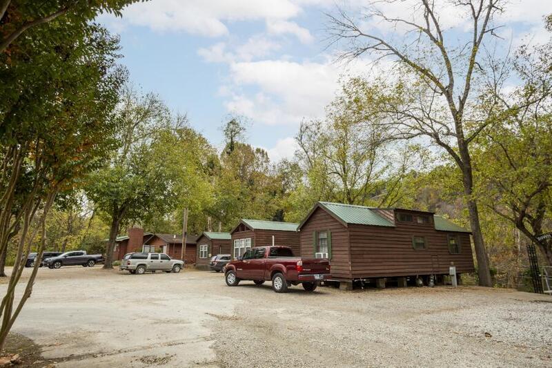 A red truck is parked in front of a row of cabins.