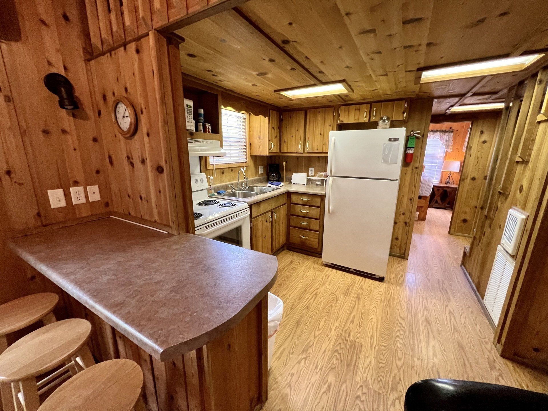 cabin kitchen with wooden cabinets , a refrigerator and a stove copper johns
