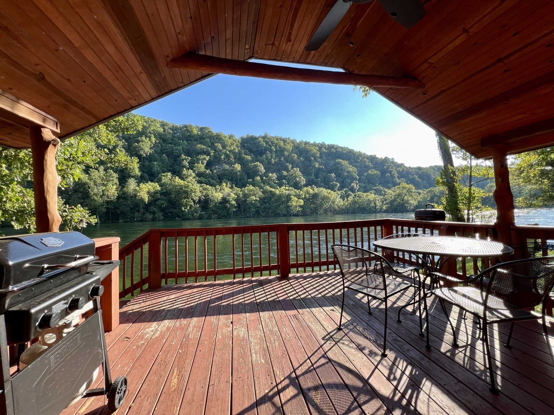 cabin 4 covered deck with propane grill on white river bank at copper johns resort