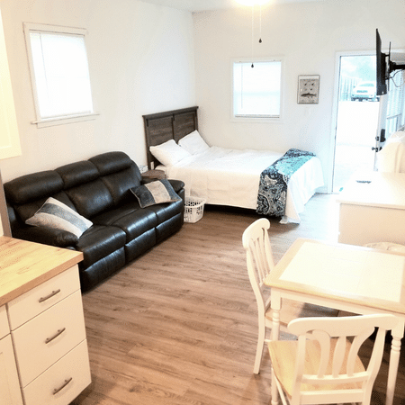 A living room with a couch a bed and a table