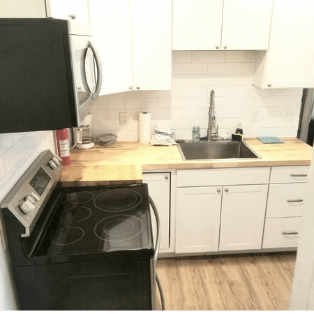 A kitchen with a black stove top oven and a sink