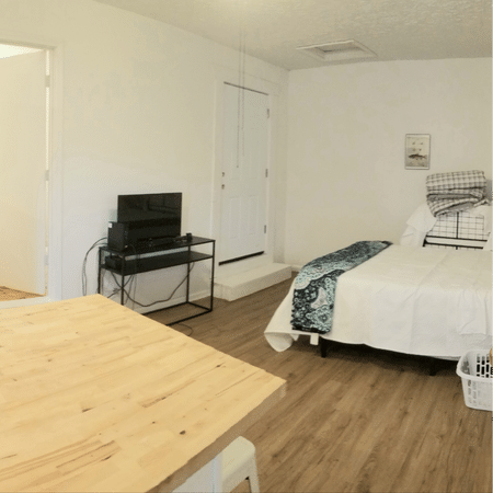 A bedroom with a bed , table , and television