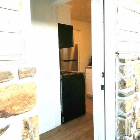 A kitchen with a stainless steel refrigerator and a black dishwasher