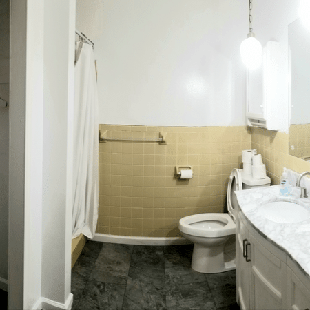 A bathroom with a toilet a sink and a mirror