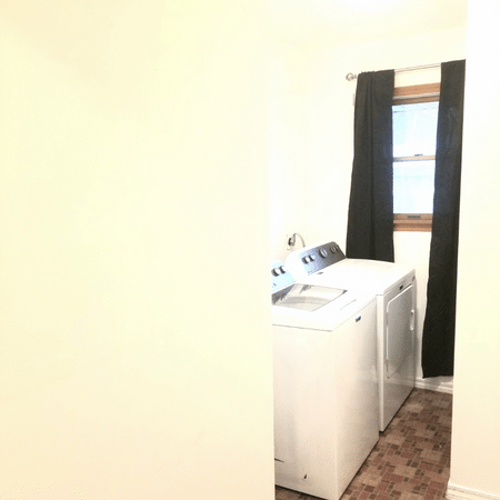 A laundry room with a washer and dryer and a window.