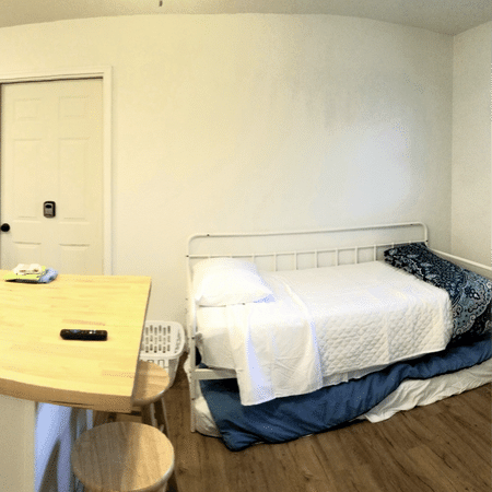 A bedroom with a bed and a table and chairs