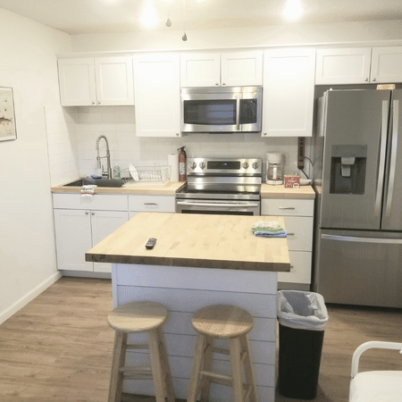 A kitchen with white cabinets and stainless steel appliances