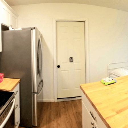 A kitchen with a stainless steel refrigerator and a wooden counter top
