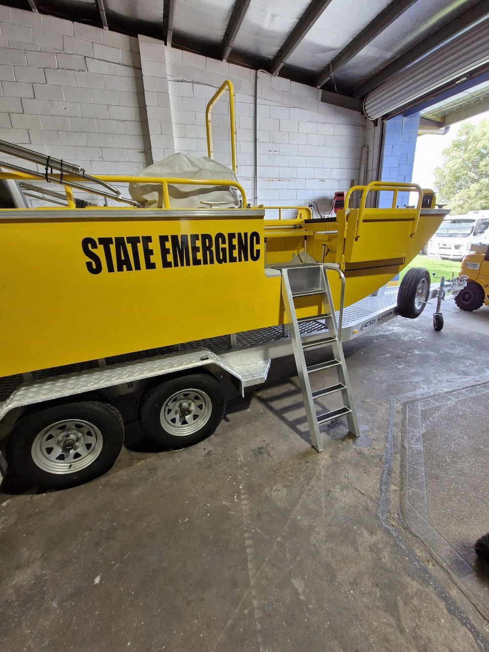Yellow Boat on Trailer With Ladder Inside Building — Cairns Metal Works in Portsmith, QLD