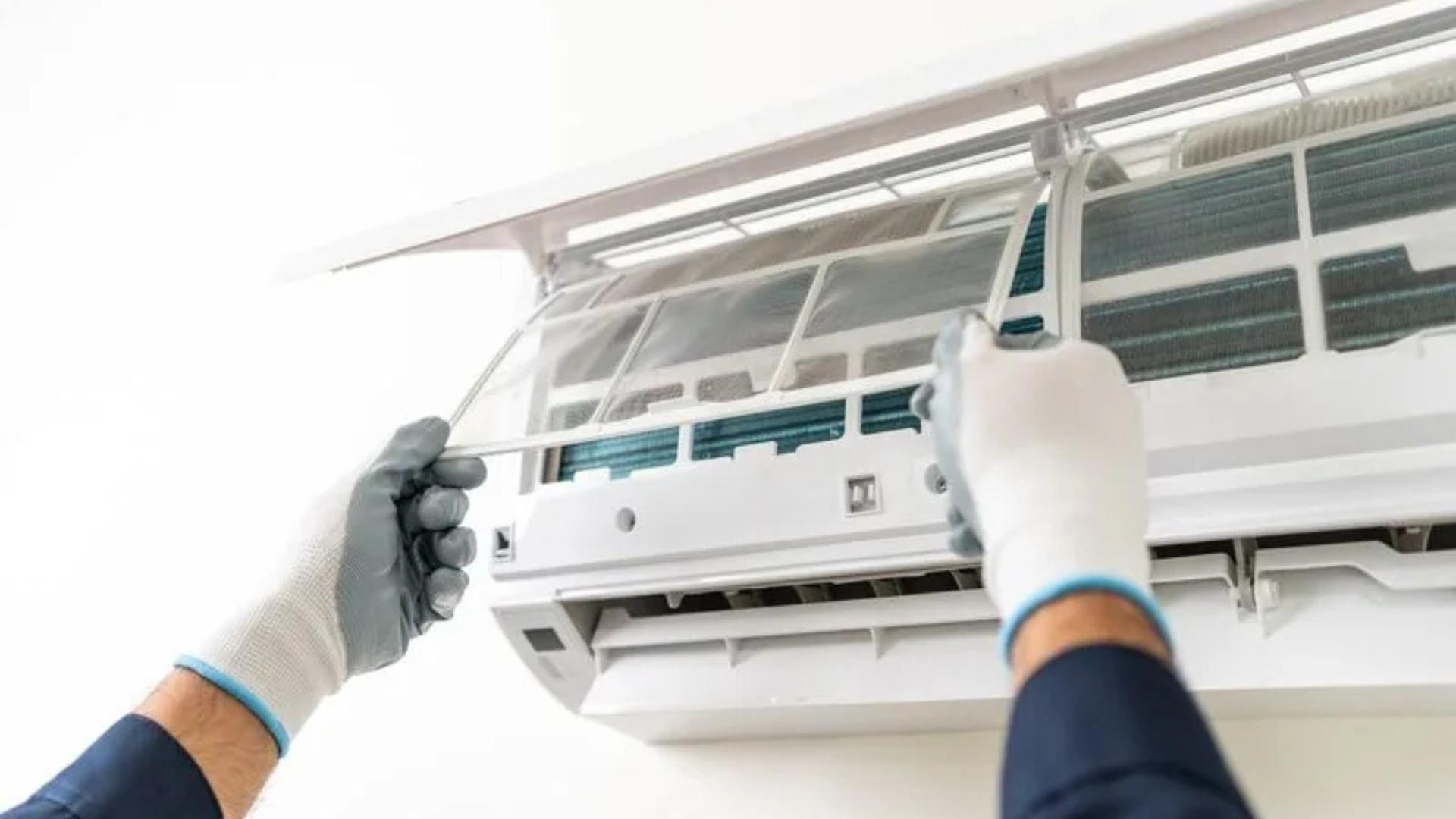 Person in gloves cleaning an air conditioner filter.