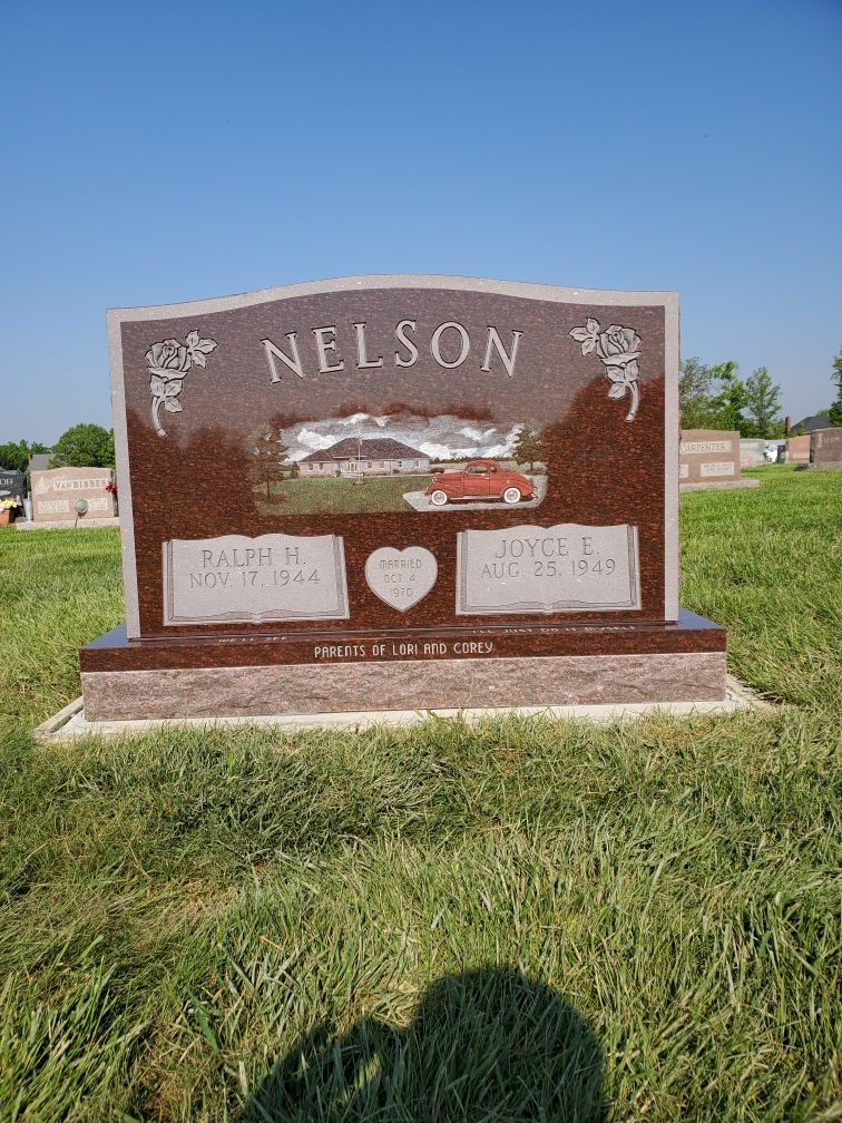 Nelson family gravestone in a grassy cemetery under a clear blue sky