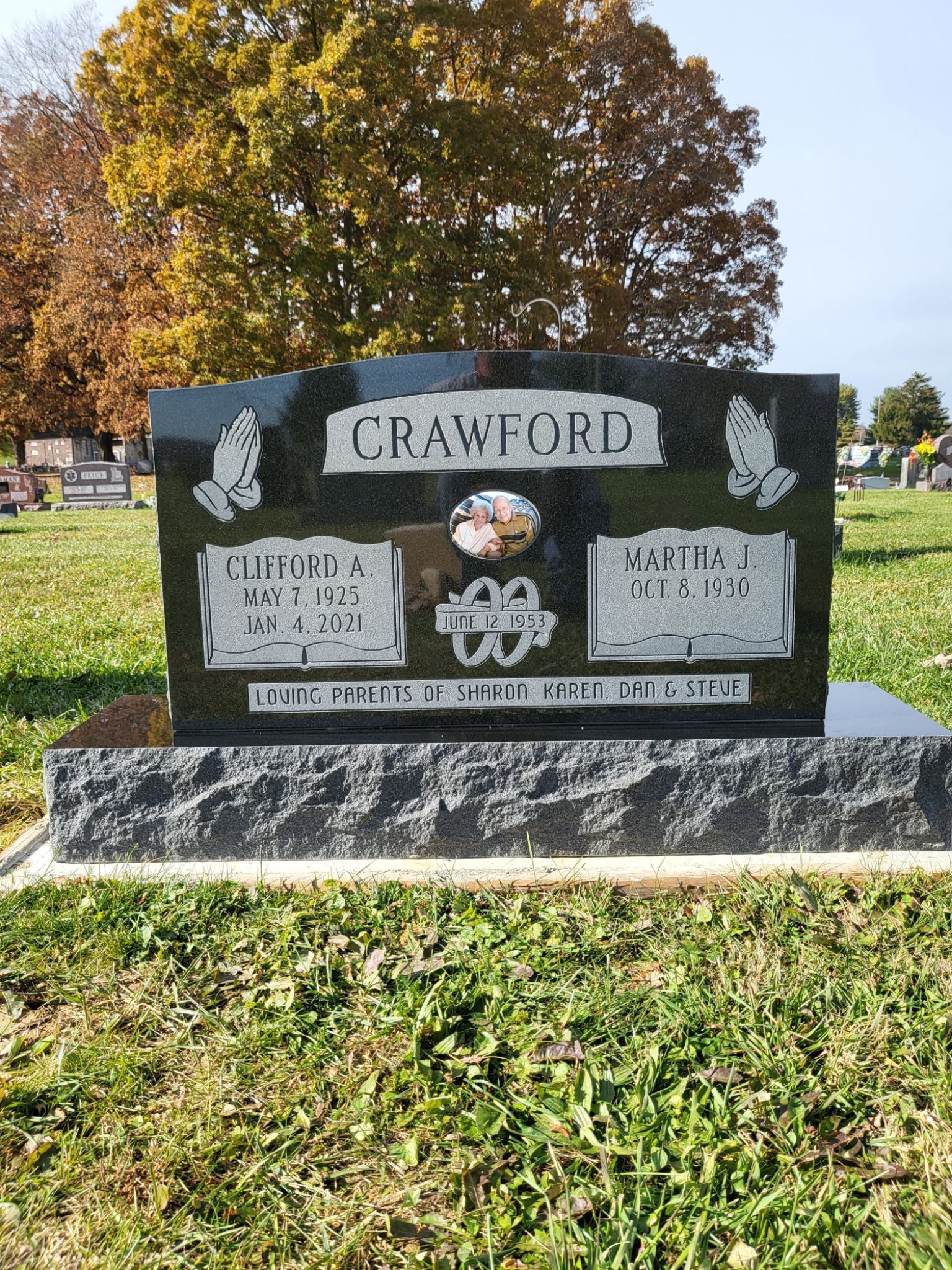 Crawford gravestone in a cemetery with autumn trees and grass behind it