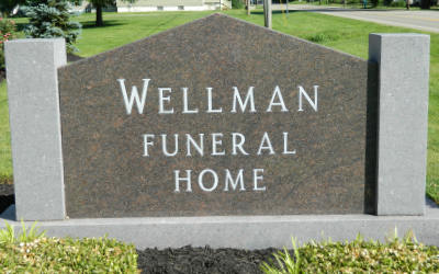 Wellman Funeral Home sign on a stone monument outdoors